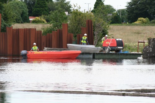 A third man has arrived via the weir walkway